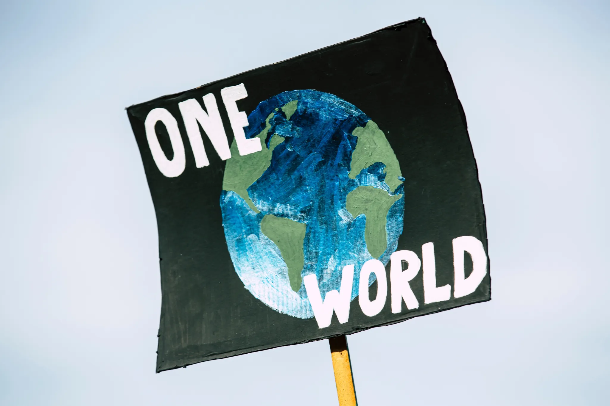 A placard saying 'one world'